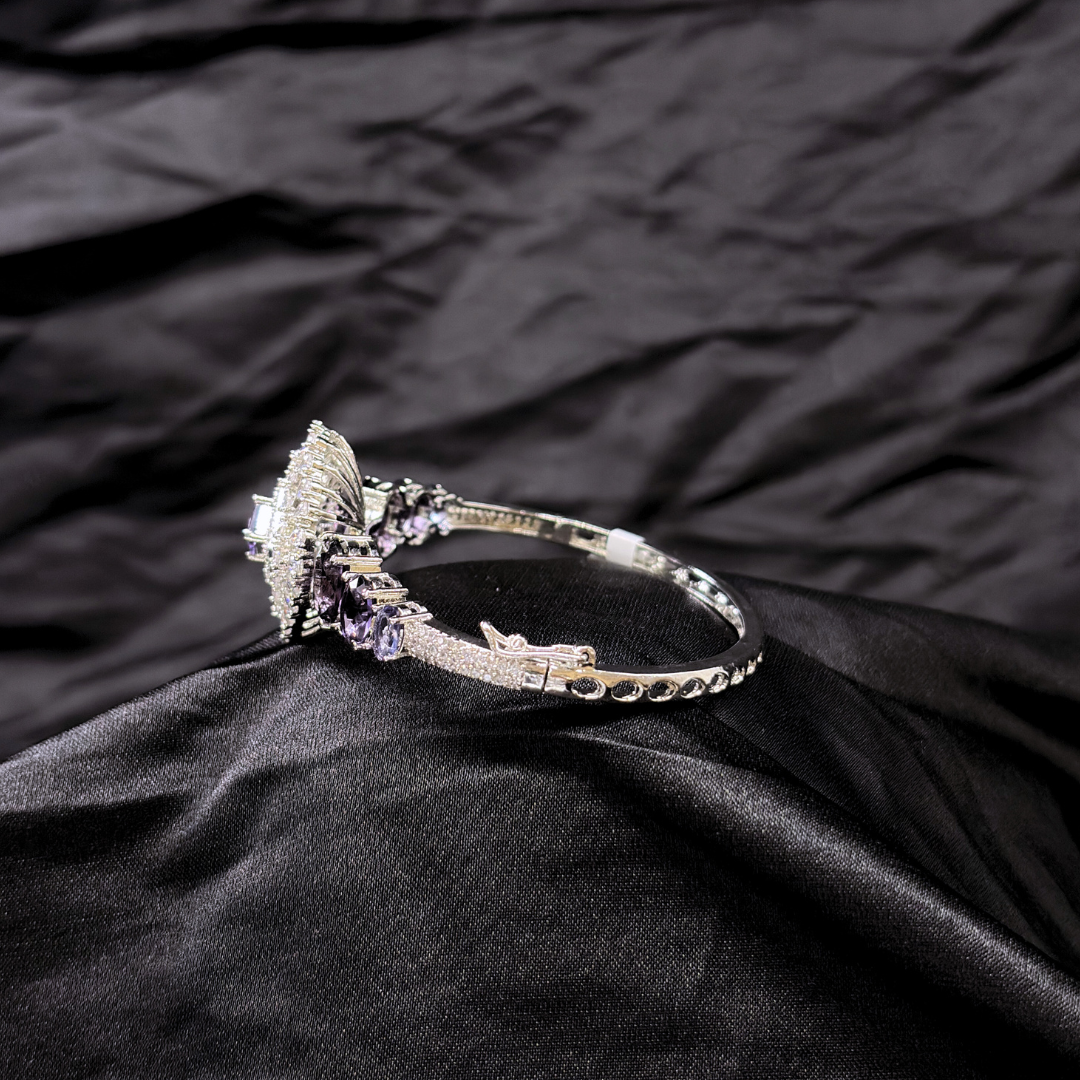 Bracelet with purple gemstones and AD circular centre piece on a black textured fabric background