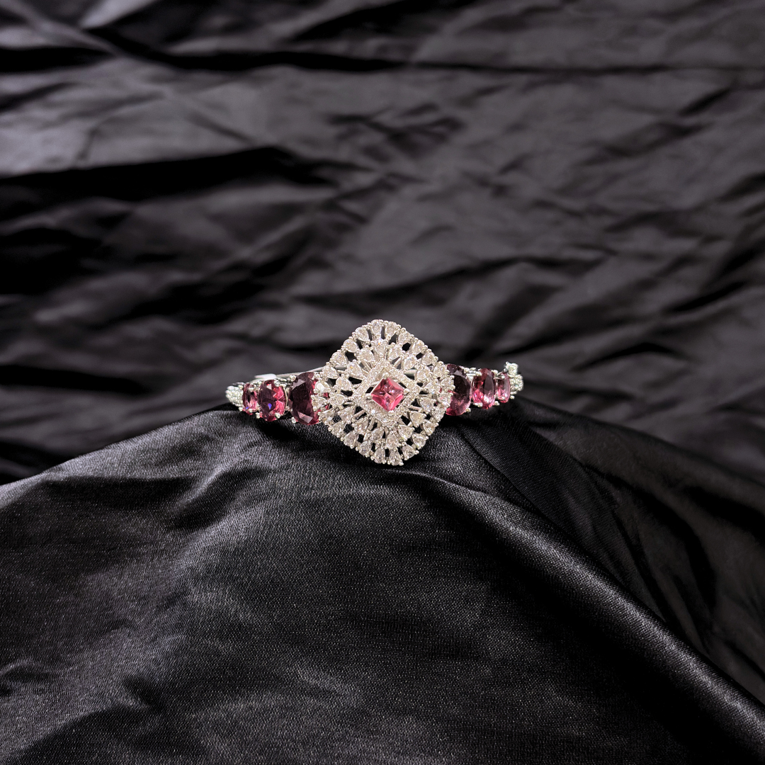 Bracelet with ruby gemstones and AD circular centre piece on a black textured fabric background