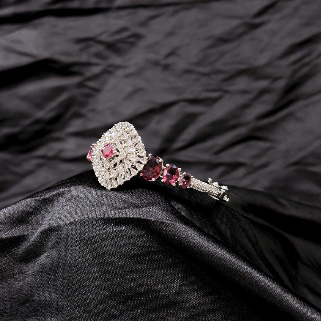Bracelet with ruby gemstones and AD circular centre piece on a black textured fabric background