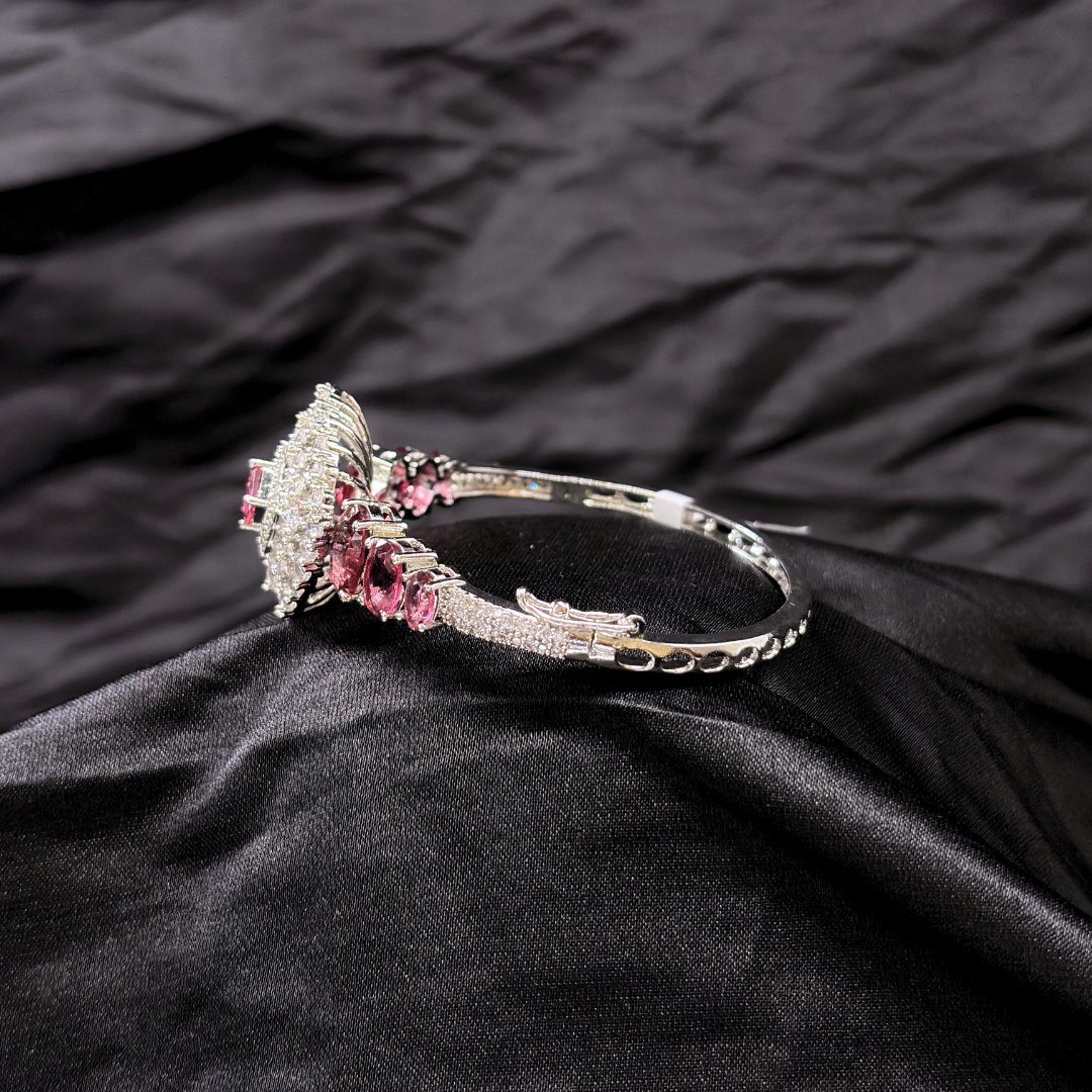 Bracelet with ruby gemstones and AD circular centre piece on a black textured fabric background