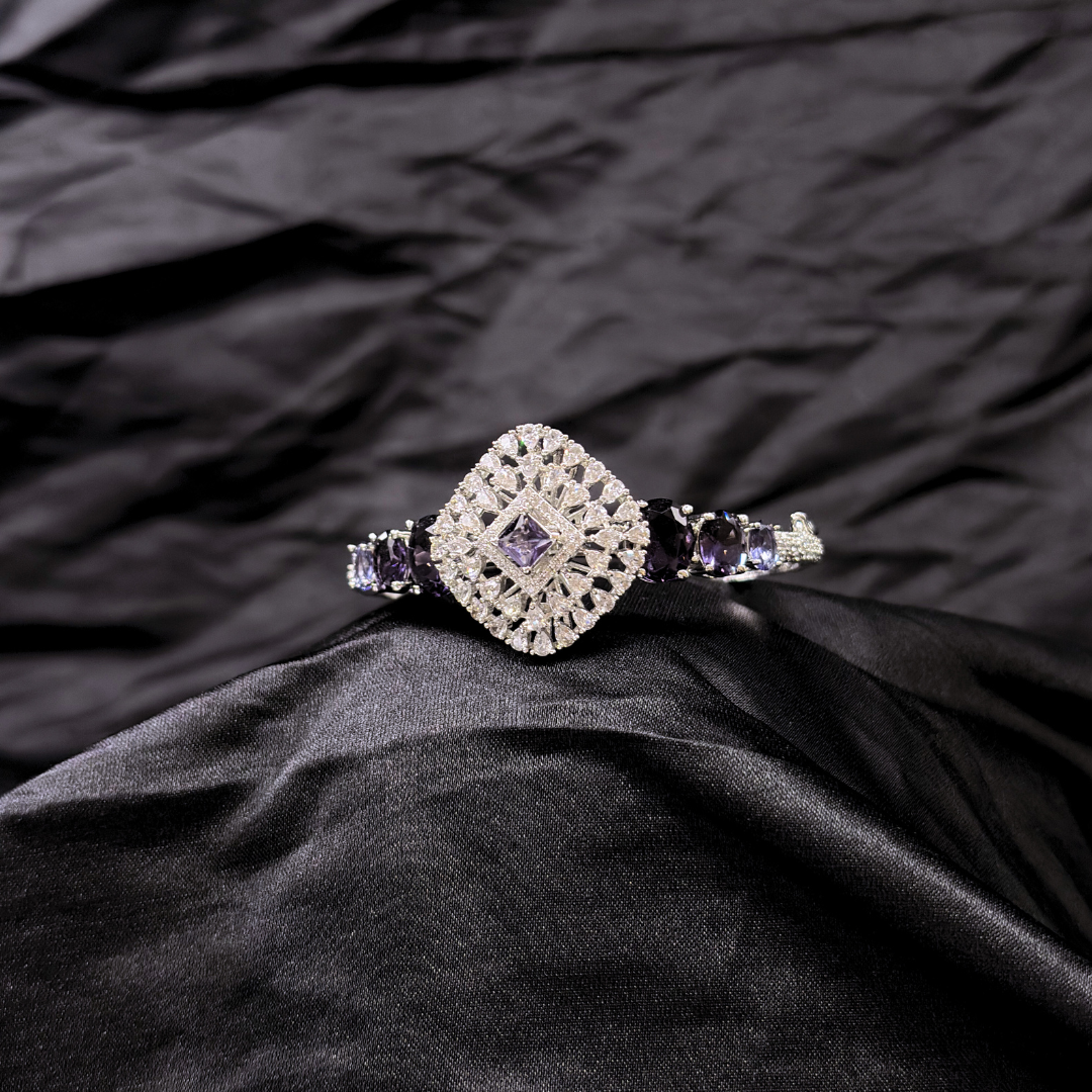 Bracelet with purple gemstones and AD circular centre piece on a black textured fabric background