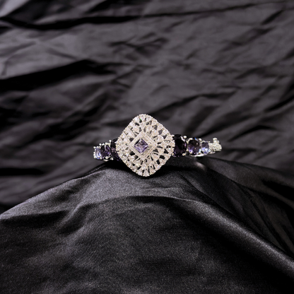 Bracelet with purple gemstones and AD circular centre piece on a black textured fabric background