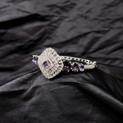 Bracelet with purple gemstones and AD circular centre piece on a black textured fabric background