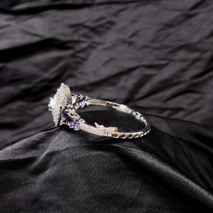 Bracelet with purple gemstones and AD circular centre piece on a black textured fabric background