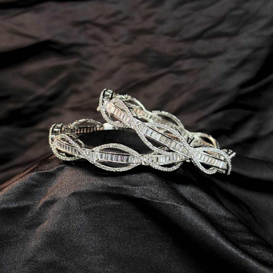 Silver AD and baguette intertwined lines chudi/ bangles that look like real diamonds   on a black textured fabric background