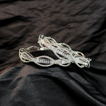 Silver AD and baguette intertwined lines chudi/ bangles that look like real diamonds   on a black textured fabric background
