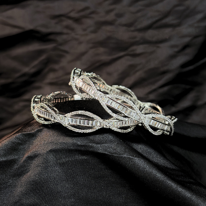 Silver AD and baguette intertwined lines chudi/ bangles that look like real diamonds   on a black textured fabric background