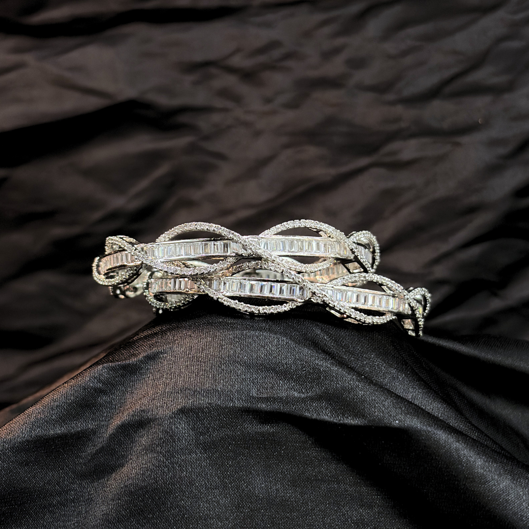 Silver AD and baguette intertwined lines chudi/ bangles that look like real diamonds   on a black textured fabric background