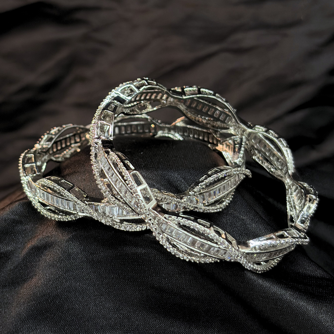 Silver AD and baguette intertwined lines chudi/ bangles that look like real diamonds   on a black textured fabric background
