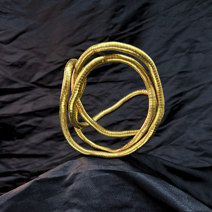 Trendy Gold mouldable necklace and bracelet with a textured design on a black textured fabric background