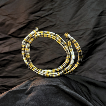Trendy Gold, silver and black mouldable necklace and bracelet with a textured design on a black textured fabric background